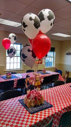 a table topped with lots of red and white checkered tables cloths covered in balloons