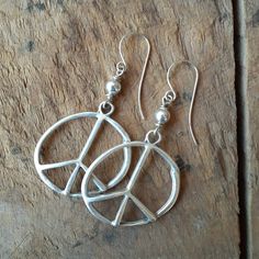 Organic antique silver peace signs are wire wrapped to sterling silver hooks. You can choose either simple silver or turquoise colored beads as an embellishment. The peace signs are 1 1/2 inches. Hanging from the earwire, the total length is 2 1/2 inches. I will include silicone ear backs so you won't have to be worried about losing one. All items are wrapped in brown tissue and tied up in a brown Kraft pillow box ready for giving away or for you to enjoy yourself. Silver Hippie Dangle Jewelry, Hippie Silver Dangle Jewelry, Symbolic Silver Hoop Earrings With Ear Wire, Adjustable Sterling Silver Peace Sign Jewelry, Silver Peace Sign Jewelry Gift, Symbolic Round Peace Sign Jewelry, Symbolic Silver Jewelry With Peace Sign, Symbolic Nickel-free Silver Hoop Earrings, Symbolic Silver Nickel-free Hoop Earrings