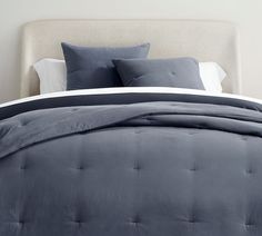 a bed with blue sheets and pillows on it