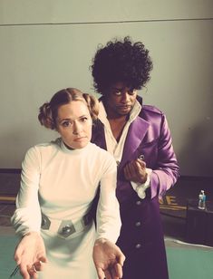 two people standing next to each other cutting a cake