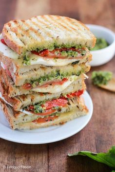 four grilled sandwiches stacked on top of each other with pesto and tomato sauce