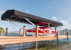 a red and white boat sitting on top of a wooden dock