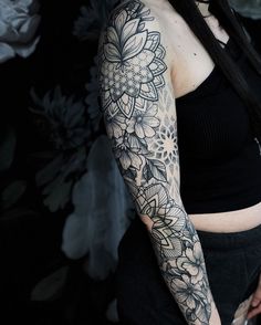 a woman with long black hair and tattoos on her arm