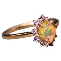 Mexican Fire Opal Amethyst Diamond Engagement Halo Ring 18K Yellow Gold. Free Domestic USPS First Class Shipping!  Free One Year Limited Warranty!  Free Gift Bag or Box with every order! Opal—the queen of gemstones, is one of the most beautiful and rarest gemstones on earth.  Every piece of opals has its colors and patterns, which is perfect for designers to create unique engagement rings for someone extra special.  Our jewelry uses 100% Natural & Ethical opal stones (NO synthetics or imitations). --------------------------------------------------------------- ABOUT THIS PRODUCT 18K Yellow Gold Mexican Fire Opal, 0.96 ct 9 Amethyst: 0.190 ct 9 Diamond: 0.042 ct Opal Size: 8x6 mm Ring Size: 7 Opal Color: Reflects Bright Green, Blue, Red & Orange Colors. Occasion: Engagement/Anniversary ---- Luxury Gold Multi-stone Opal Ring, Exquisite Gold Amethyst Ring With Gemstone Accents, Luxury Yellow Gold Opal Ring With Accent Stones, Luxury Yellow Gold Opal Ring With Gemstone Accents, Gold Luxury Amethyst Multi-stone Ring, Luxury Gold Amethyst Multi-stone Ring, Luxury Gold Multi-stone Amethyst Ring, Gold Opal Ring With Gemstone Accents, Luxury Gold Opal Ring With Center Stone