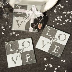 three coasters with the word love on them and confetti scattered around it