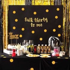 a black table topped with lots of food and drinks next to a sign that says 50 and fabulous