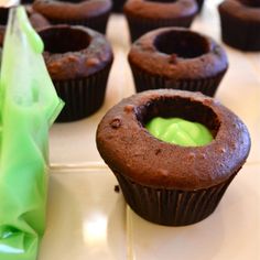 chocolate cupcakes with green icing on a table