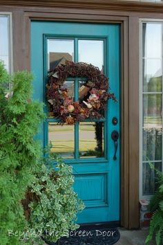 a blue front door with a wreath on it