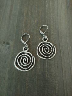 Bohemian Silver Spiral Earrings    These earrings are versatile and comfortable to wear. They will go with almost any outfit. They are great for gift giving or as a treat for yourself. 🌻 Measurements: The focal spiral charm is approximately 1 inch in diameter. The earring drop size/diameter is approximately 1.10 inch. (if choosing bean hooks, please see below.) The earring's total size (with the hooks included) is around 1.50 inch. With bean hooks: all the sizes will increase by 1 inch.  These earrings will be approximately 2 inches in total length with bean hooks. ⭐Colors may slightly vary due to the differences in screen monitor settings vs. real life lightings. Shipping:   I ship within 2 business (non-holiday) days of the purchase. The shipping service I use is First Class Package off Free Spirit Gifts, Antique Silver Earrings, Spirit Gifts, Holiday Day, Swirl Earrings, Spiral Earrings, Earrings Bohemian, Free Spirit, 10 Inch