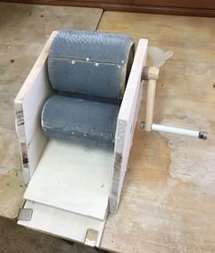 a blue chair sitting on top of a wooden floor next to a piece of wood