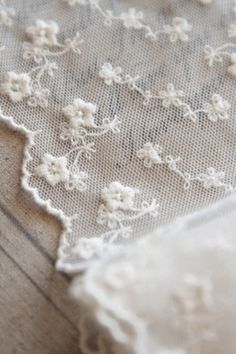 an embroidered piece of cloth with white flowers on it