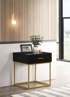 a black and gold side table in front of a window with a plant on it