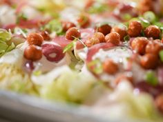 a close up view of a salad with chickpeas and lettuce on it