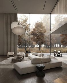 a modern living room with large windows and white couches in front of the glass wall