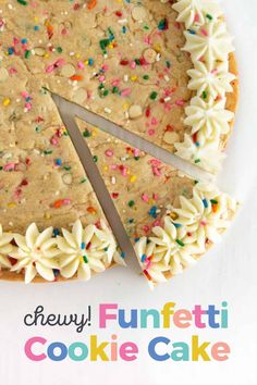 a cookie cake with white frosting and sprinkles cut into four slices