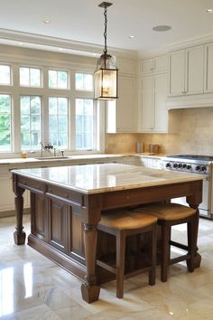 a large kitchen with an island and two stools