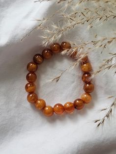 This elastic bracelet is made from unique amber colored beads. Luxury Amber Beaded Bracelets For Gift, Luxury Amber Beaded Bracelets For Gifting, Orange Stretch Bracelet With 8mm Beads, Spiritual Amber Bracelets With Polished Beads, Brown Beaded Stretch Bracelet With Round Beads, Amber Beaded Bracelets For Healing, Amber Beaded Bracelets With Polished Beads As Gift, Amber Beaded Bracelets As Gift, Amber Beaded Bracelets For Gift