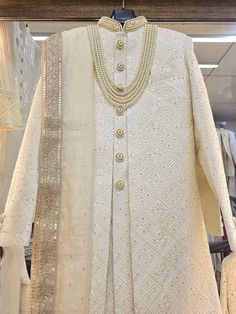 Make a grand statement on your special day with a luxurious Sherwani crafted from premium fabrics (like silk, brocade, or georgette) for ultimate comfort and sophistication. Our collection boasts a variety of designs to suit every taste: Classic elegance: Opt for a timeless Sherwani with intricate embroidery on the collar or cuffs. Modern flair: Go for a Sherwani with a unique neckline or a trendy color palette. Regal opulence: Choose a Sherwani with rich embellishments like zardozi work for a t White Sherwani For Men, Unique Mens Wedding Suits, White Sherwani, Zardozi Work, Sherwani For Men, Jackets Men Fashion, Silk Brocade, Wedding Suits Men, Intricate Embroidery