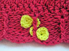 a close up of a knitted object with two yellow buttons