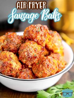 air fryer sausage balls in a white bowl on a wooden table with text overlay