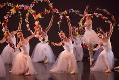 a group of ballerinas in tulle skirts and flower wreaths