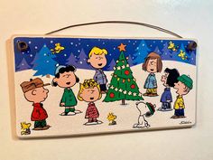 a charlie brown christmas card with peanuts around the tree