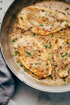 chicken with gravy in a skillet on top of a white countertop