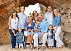 a family is posing for a photo in front of an arch at the beach with their two children