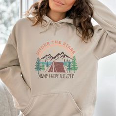 Experience the serenity of the great outdoors with our 'Under the Stars and Away from the City' hoodie. This cozy sweatshirt is perfect for camping enthusiasts and outdoor lovers. Embrace the camp aesthetic and showcase your love for the wilderness with this stylish and comfortable hoodie. It also makes a great gift for hiking enthusiasts and anyone who enjoys spending time in nature. Stay warm and show off your passion for the outdoors with this camping hoodie. This unisex heavy blend hooded sweatshirt is relaxation itself. Made with a thick blend of cotton and polyester, it feels plush, soft and warm, a perfect choice for any cold day. In the front, the spacious kangaroo pocket adds daily practicality while the hood's drawstring is the same color as the base sweater for extra style point Letter Print Hoodie For Adventure In Fall, Relaxed Fit Hoodie With Graphic Print For Outdoor Activities, Relaxed Fit Hoodie With Graphic Print For Outdoor, Outdoor Hoodie With Letter Print In Relaxed Fit, Outdoor Relaxed Fit Hoodie With Letter Print, Relaxed Fit Sweatshirt With Kangaroo Pocket For Outdoor Activities, Relaxed Fit Outdoor Hoodie With Letter Print, Relaxed Fit Sweatshirt With Kangaroo Pocket For Outdoor, Relaxed Fit Hoodie Sweatshirt For Outdoor Activities