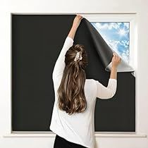 a woman is holding up a large black piece of art