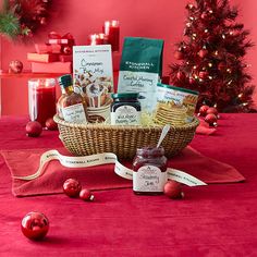 a basket filled with food sitting on top of a table next to a christmas tree