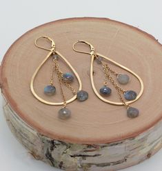 Labradorite Earrings, Teardrop Hoop Earrings, Gold or Silver, Gray Labradorite Earring A cascade of always chic labradorite teardrop beads sparkle with an array of colors when suspended from these handmade teardrop hoops. Hoops are medium-size--handmade with 18 gauge wire. They have a slightly hammered texture and are tumbled for a nice shine. Blue flash labradorite beads are approximately 6 mm. Approximate length is 2 3/4 - 3 inches. Also available in sterling silver and rose gold filled. Secur Red Garnet Earrings, Teardrop Hoop Earrings, Earrings Teardrop, Hammered Earrings, Mixed Metal Jewelry, Earring Ideas, Labradorite Earrings, Hoop Earrings Gold, Earrings Inspiration