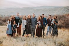 a group of people standing on top of a grass covered field next to each other