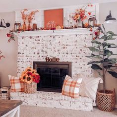 a living room filled with furniture and a fire place covered in fall decorations on top of a mantel