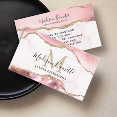 two business cards sitting on top of a black plate