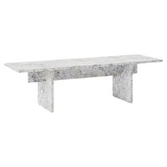 a white marble bench sitting on top of a wooden table