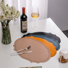 a table topped with plates and glasses filled with food next to a bottle of wine