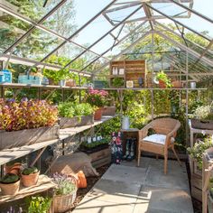 the inside of a greenhouse with lots of plants and potted plants in pots on shelves