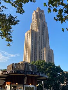 a tall building with a clock on it's side and trees in the foreground