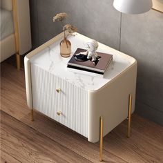 a white side table with a book on it and a lamp next to it in a room