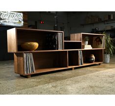 a wooden shelf with various records and vases on it