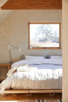 a bed sitting under a window in a bedroom