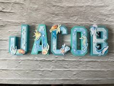 the word jacob is made out of wood and painted with sea animals