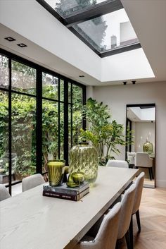 a dining room table with two vases on top of it next to some chairs