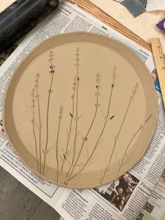 a plate with flowers on it sitting on top of a table next to some papers