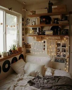 a bed with white sheets and pillows in front of a window filled with christmas lights