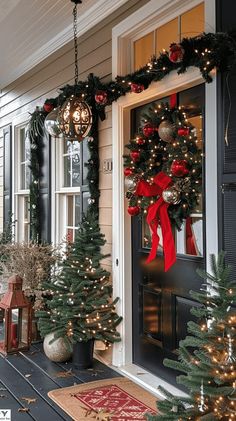 christmas decorations on the front porch with wreaths and lights hanging from the door frame