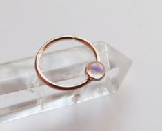 This moonstone septum ring is handmade by me with rose gold filled hard wire. This a more simple and affordable alternative to my hammered septum rings (gold filled is similar to gold plated but the plating is much thicker making it a higher quality. the plating will not come off as often happens with gold plated jewelry.).  Soldered onto the ring is a 3mm rose gold filled setting with a 3mm moonstone set inside of it. The ring is available in 16, 18, and 20 gauge and you can also choice between Minimalist Hypoallergenic Rose Gold Septum Ring, Minimalist Rose Gold Septum Ring As Gift, Hoop Septum Piercing, Gauge Septum, Hoop Septum, Septum Hoop, Septum Rings, Rings Gold, Septum Piercing