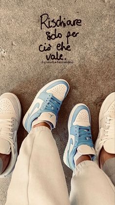 two people standing next to each other wearing white and blue shoes with the words rise above them