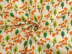 an orange and green fox print fabric with trees in the background on a white ground